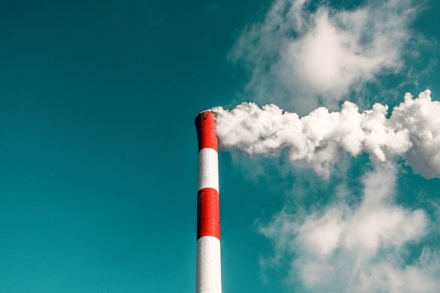 Chimney with smoke in front of the sky